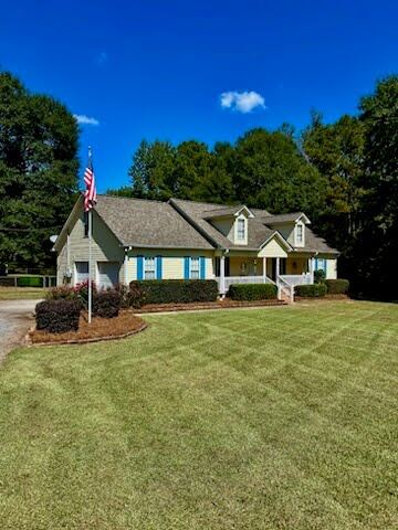 Maintained front yard with American flag and trimmed shrubs in Upson County, GA